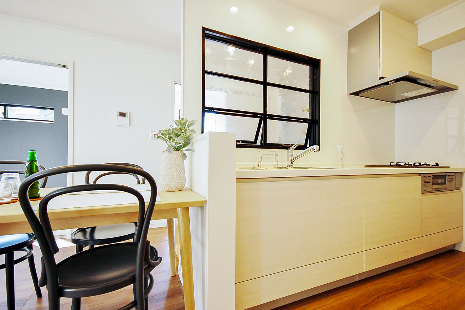 キッチン前面の壁にはデザイン性のある室内窓を設え、空間を上手に仕切るアクセントに。